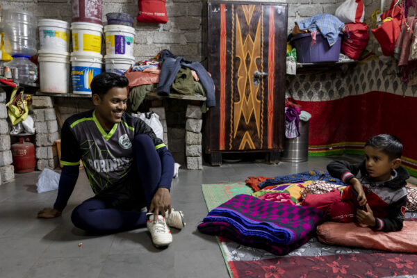 Rohingya refugee from Hyderabad, India, spends a few moments with his son before leaving for an evening game of football. 